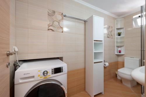 a washing machine in a bathroom with a toilet at Evangelia cozy View in Agios Nikolaos