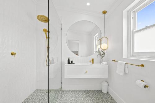 a white bathroom with a sink and a mirror at 1930's Character Cottage - Beautifully Restored in McLaren Vale