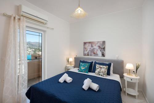 a bedroom with a blue bed with two pillows at Evangelia cozy View in Agios Nikolaos