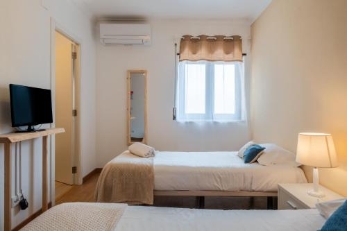 a bedroom with two beds and a window at West Side Guesthouse in Peniche