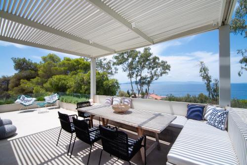 Un patio con una mesa y sillas de madera. en Maya Luxury Residence, en Aegenitissa