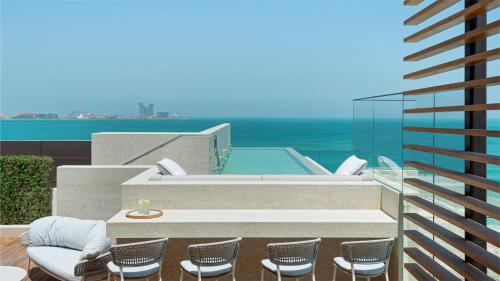 eine Terrasse mit Stühlen und einem Whirlpool auf einem Gebäude in der Unterkunft Jumeirah Al Naseem Dubai in Dubai