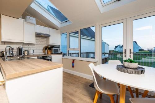 a kitchen with white cabinets and a table with chairs at Sunny Cottage in Wexford