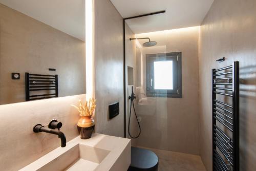 a bathroom with a sink and a shower at Maya Luxury Residence in Aegenitissa