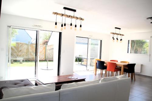 un salon avec une table et des chaises dans l'établissement Les Marquises - bord de mer, à Roscoff