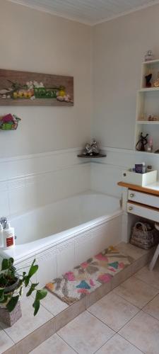 a bath tub sitting in a room with a rug at MALPAS125 maison 6 chambres 10personnes in Accons