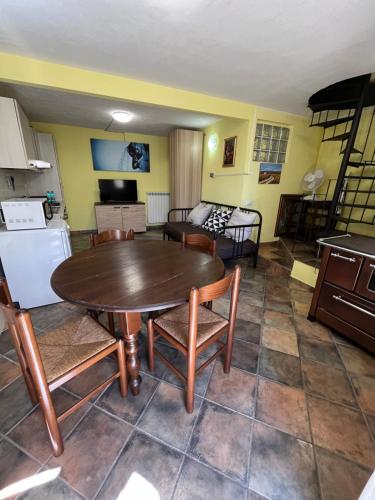 una cucina e un soggiorno con tavolo e sedie di da sciuri case vacanza barisciano a Barisciano