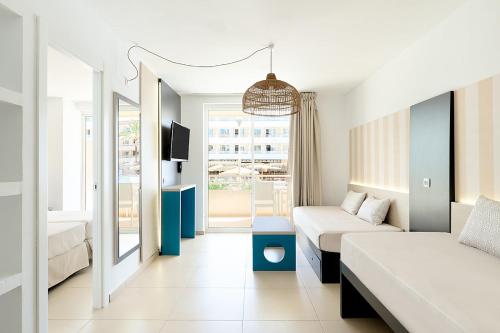 マガルフにあるFERGUS Club Mallorca Waterparkのベッド2台とソファが備わるホテルルームです。
