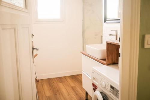 une salle de bain blanche avec un lavabo et une fenêtre dans l'établissement Maginot, à Tours