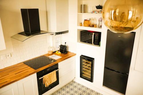 une cuisine avec un réfrigérateur noir et une cuisinière dans l'établissement Maginot, à Tours