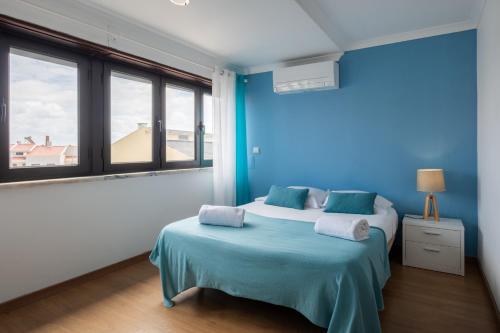 a blue room with two beds and a blue wall at West Side Guesthouse in Peniche