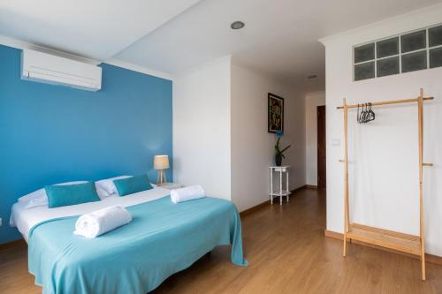 a blue bedroom with a bed with two pillows on it at West Side Guesthouse in Peniche