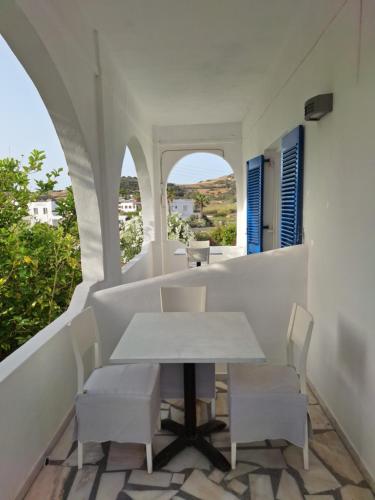 una mesa y sillas en un balcón con ventana en Εvi Evan Hotel, en Galissas