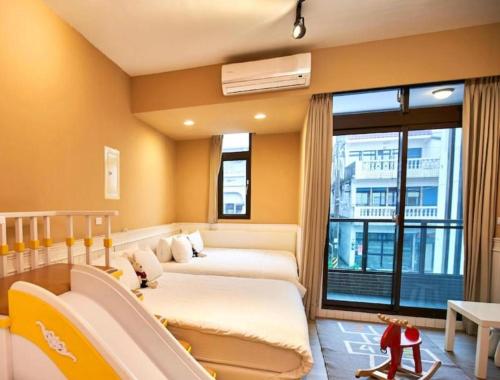 a hotel room with two beds and a window at 無門禁24小時進出-蝴蝶結溜滑梯親子民宿-免費停車 in Yuanshan