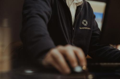 a person sitting at a computer with their hand on a keyboard at Vilar Oporto Hotel in Porto