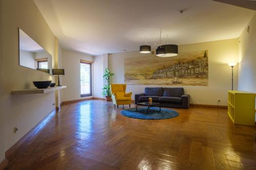a living room with a couch and a chair at Vilar Oporto Hotel in Porto