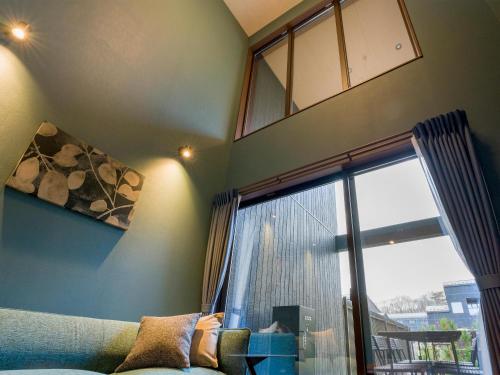 a living room with a couch and a large window at Rakuten STAY VILLA Nasu in Nasu