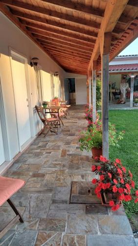 a patio with a table and chairs and flowers at Villa dos Corcéis in Esposende