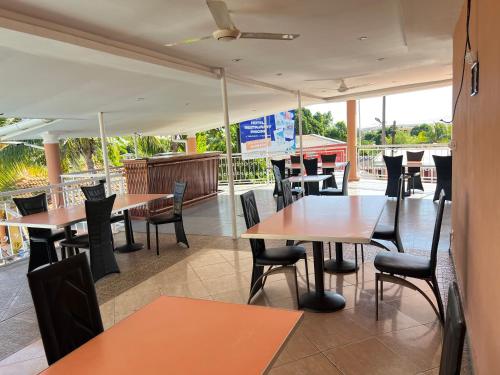 an empty restaurant with tables and chairs and a view at Hôtel Sofia Bellevue in Antsohihy