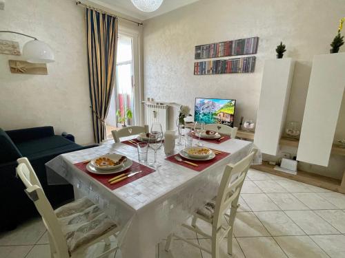 a living room with a white table and chairs at Appartamento piscina&mare in Lido di Ostia