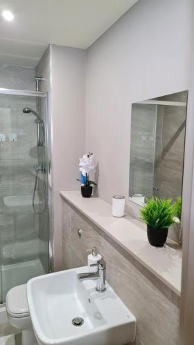 a bathroom with a sink and a shower and a toilet at KEST Luxury Apartment in Leeds
