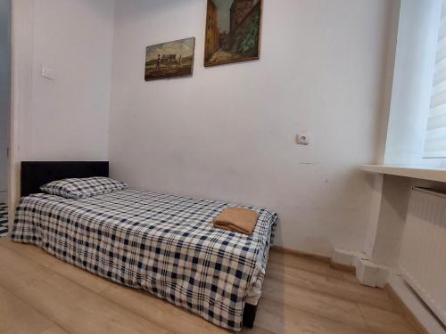 - une petite chambre avec un lit et une couverture tressée dans l'établissement Centrum Lwowska, à Varsovie