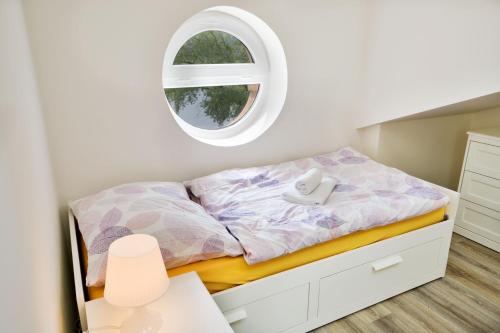 a small bedroom with a bed with a window at Apartmány Děčín in Děčín