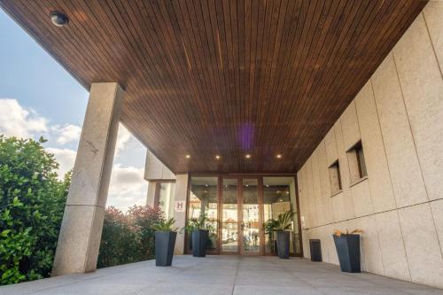 a lobby of a building with a wooden ceiling at Vilar Oporto Hotel in Porto