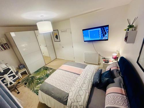 a bedroom with a bed and a flat screen tv at Cosy private double room & sofa-bed room in vibrant Hatfield neighbourhood in Hatfield