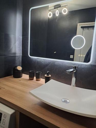 une salle de bain avec un lavabo et un miroir sur un comptoir dans l'établissement Au coin des Thermes - Draps en option, à Luz-Saint-Sauveur