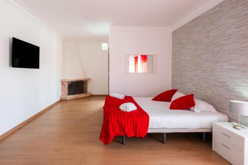 a bedroom with a white bed with red pillows at West Side Guesthouse in Peniche