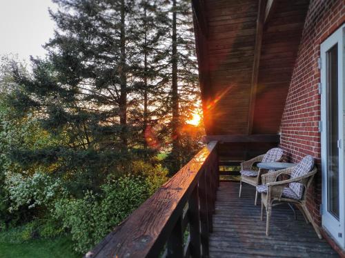 a deck with two chairs and a table on a house at Historic Residence with Lake View in Stenstrup