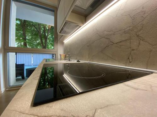Un baño con lavabo y una gran ventana. en Urban Nest Terrace Suite, en Bolonia