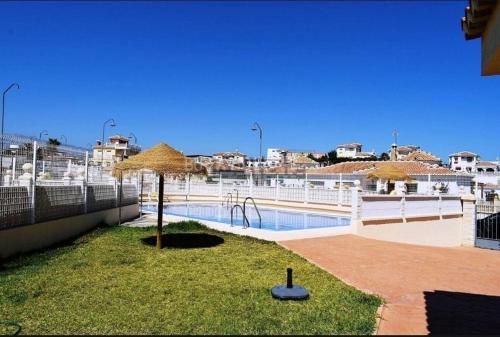 una piscina con sombrilla en un patio en Cozy Duplex Niza Beach, en Torre del Mar