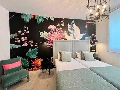 a bedroom with two beds and a wall with flowers at Apartamentos Realejo Campo del Príncipe 3000 in Granada