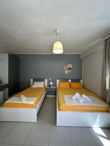 two beds in a small room with yellow and white at Potami Seashell in Himare