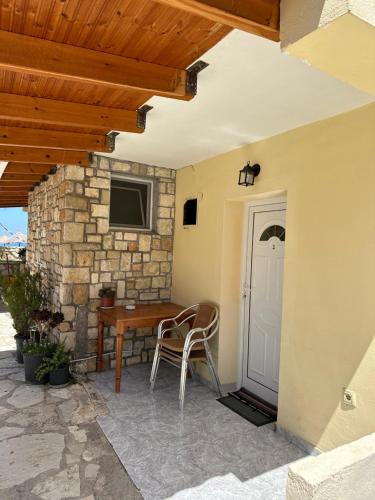 a patio with a table and chairs and a door at Potami Seashell in Himare