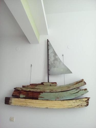 a wooden boat with a sail on a wall at Oikeion in Ermoupoli