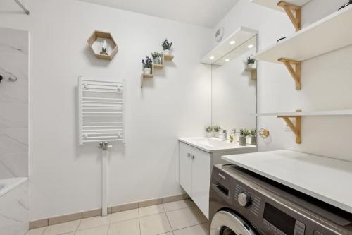 une salle de bain blanche avec un lavabo et un miroir dans l'établissement Direct access to Paris - 6 guests, à Villejuif