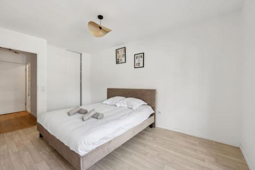 - une chambre avec un grand lit aux murs blancs dans l'établissement Direct access to Paris - 6 guests, à Villejuif