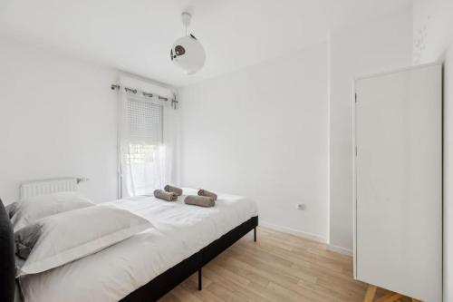 une chambre blanche avec un lit et un miroir dans l'établissement Direct access to Paris - 6 guests, à Villejuif