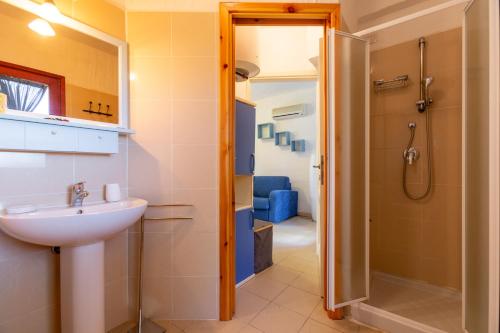 La salle de bains est pourvue d'un lavabo et d'une douche. dans l'établissement Villette con piscina zona Porto Pino, à SantʼAnna Arresi