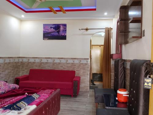 a living room with a red couch in a room at Nambal Hotel, Kalam in Kalām
