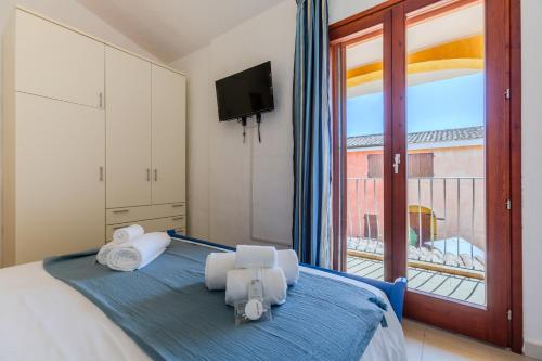 - une chambre avec un lit et une grande fenêtre dans l'établissement Villette con piscina zona Porto Pino, à SantʼAnna Arresi