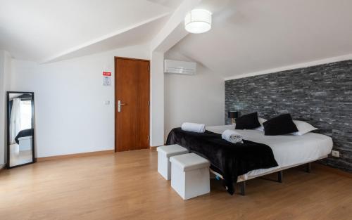 a bedroom with a bed and a brick wall at West Side Guesthouse in Peniche