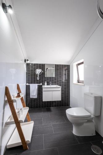 a bathroom with a toilet and a sink and a tub at West Side Guesthouse in Peniche