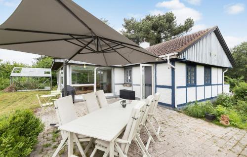 a table with an umbrella in front of a house at 3 Bedroom Beautiful Home In Ølsted in Ølsted