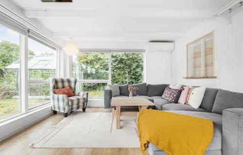 a living room with a gray couch and a chair at 3 Bedroom Beautiful Home In Ølsted in Ølsted
