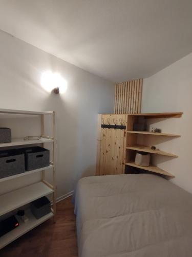 - une chambre avec un lit et des étagères dans l'établissement Briançon petit appart cosy au cœur du centre-ville, à Briançon