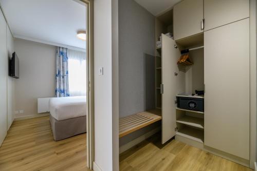 a small bedroom with a bed and a closet at Best Western Plus Ajaccio Amirauté in Ajaccio